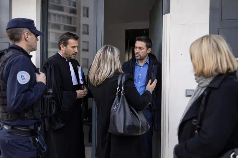 Quatre personnes discutant dans un couloir de bureau